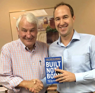 Tom and Kevin smiling in Rochester, NY, shaking hands while presenting the book 'Built Not Born'.