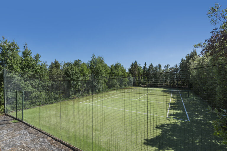 Private tennis court in lush green setting at Tuscany writers retreat villa